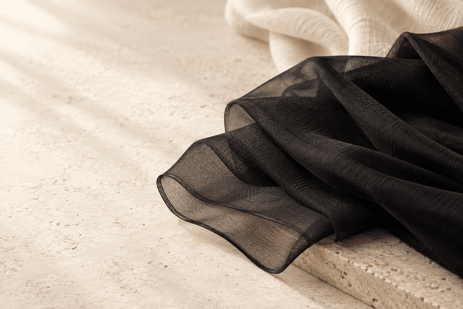 Black sheer tights fabric on an ivory textile background